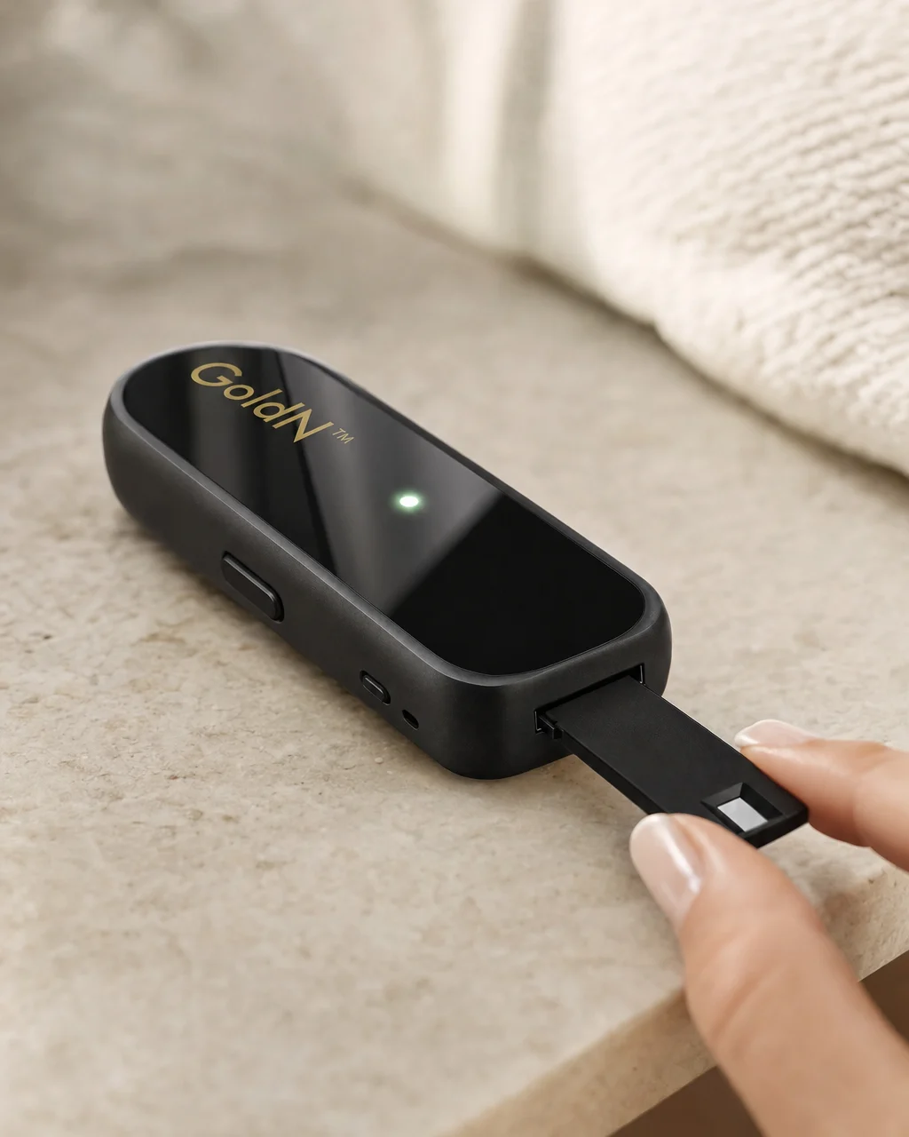 Fingertips sliding a single-use cartridge into the GoldN Companion