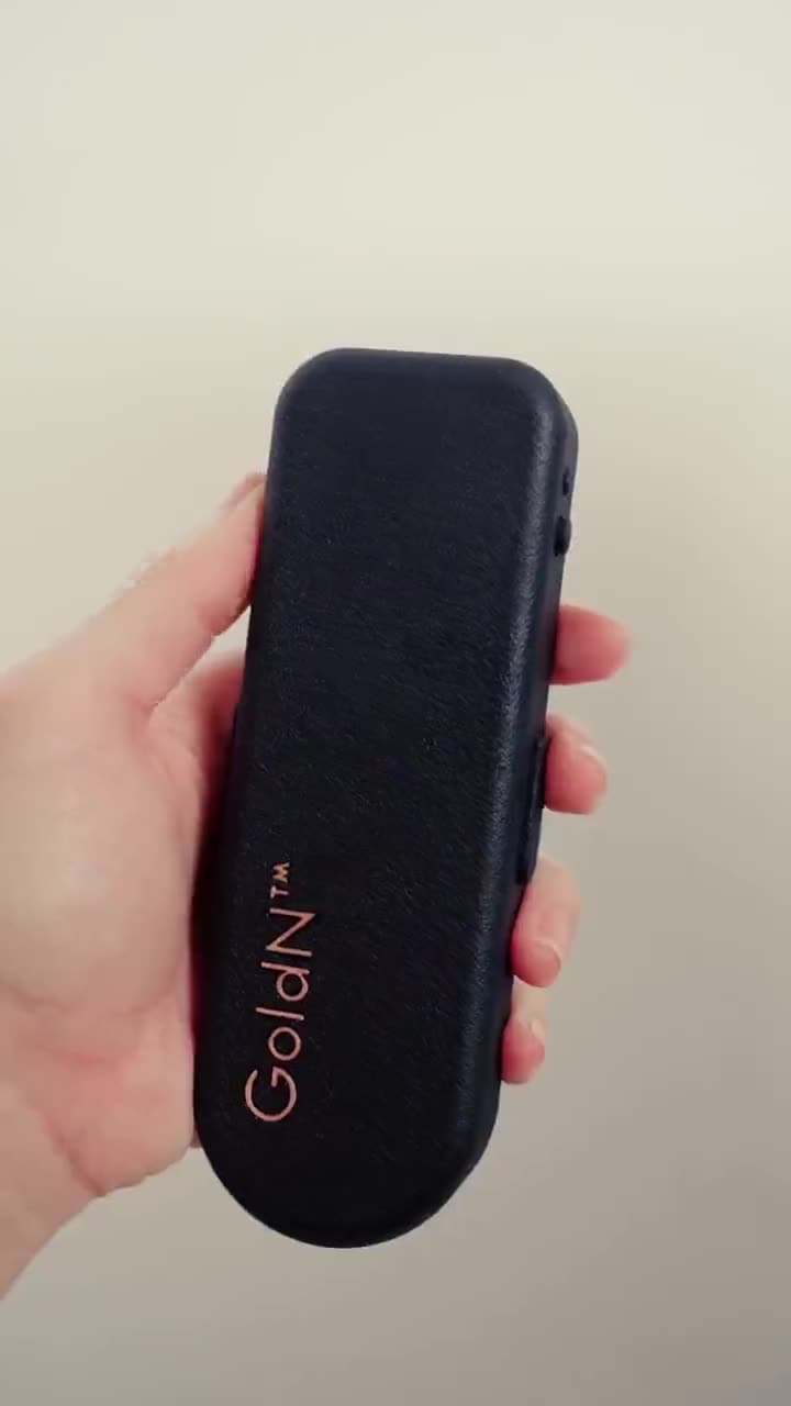 A hand holding the GoldN Companion prototype